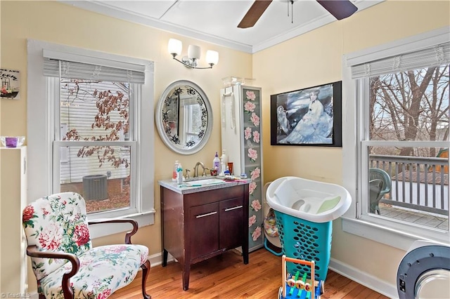 sitting room with ceiling fan, light hardwood / wood-style floors, sink, and crown molding