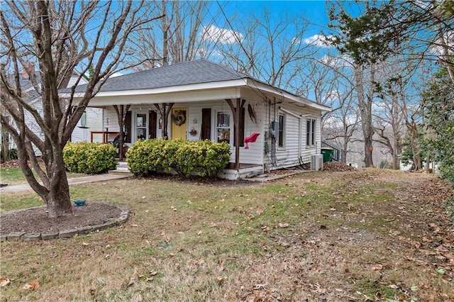 view of front facade with central air condition unit, a front lawn, and covered porch