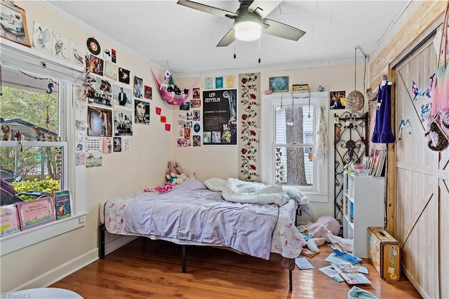 bedroom featuring hardwood / wood-style floors, ceiling fan, and crown molding