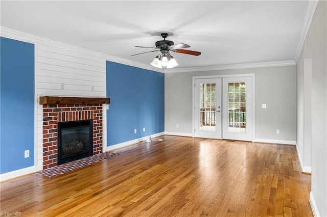 5119 Spiral Wood Dr, Clemmons, NC 27012 - unfurnished living room with ornamental molding, wood finished floors, a ceiling fan, a brick fireplace, and french doors