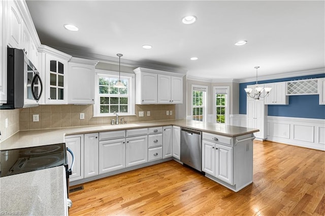 5119 Spiral Wood Dr, Clemmons, NC 27012 - kitchen with stainless steel appliances, a chandelier, a peninsula, white cabinets, and ornamental molding