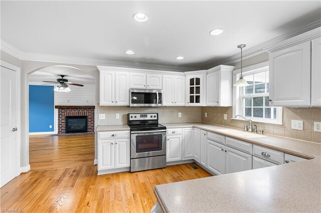 5119 Spiral Wood Dr, Clemmons, NC 27012 - kitchen with stainless steel appliances, ceiling fan, ornamental molding, white cabinets, and hanging light fixtures