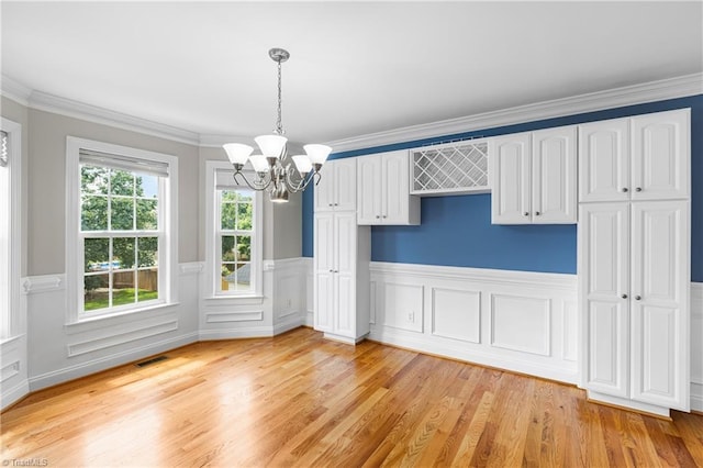 5119 Spiral Wood Dr, Clemmons, NC 27012 - unfurnished dining area featuring a chandelier, light wood-type flooring, a wainscoted wall, and ornamental molding