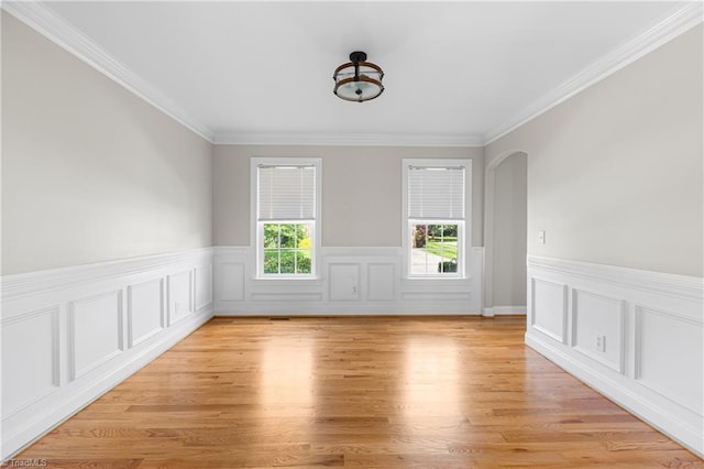 5119 Spiral Wood Dr, Clemmons, NC 27012 - spare room featuring crown molding, light wood-style floors, wainscoting, and arched walkways
