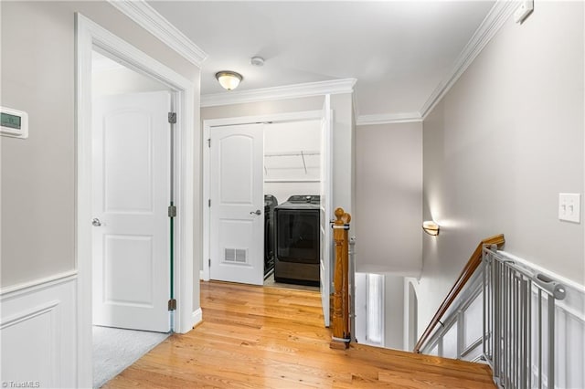 5119 Spiral Wood Dr, Clemmons, NC 27012 - hall featuring washer / clothes dryer, an upstairs landing, ornamental molding, and light wood finished floors