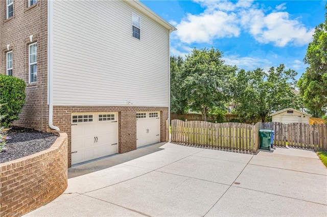 5119 Spiral Wood Dr, Clemmons, NC 27012 - view of side of home featuring brick siding, driveway, and a garage