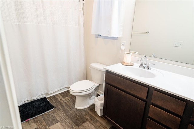 bathroom with toilet, vanity, and hardwood / wood-style flooring