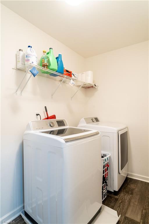 clothes washing area with independent washer and dryer and dark hardwood / wood-style floors