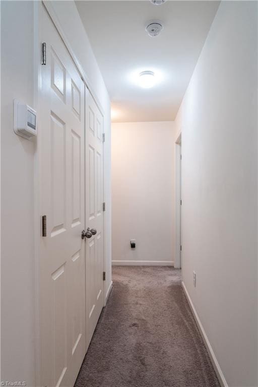 corridor featuring dark colored carpet