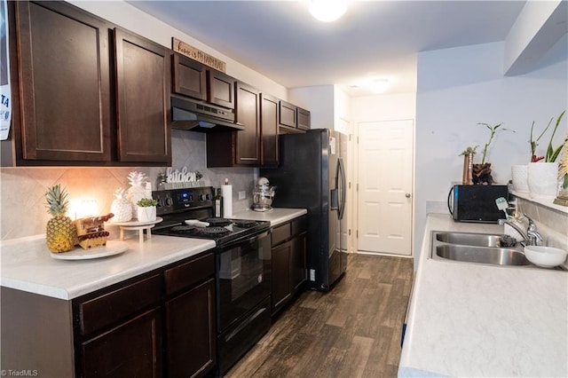 kitchen featuring dark wood-type flooring, black appliances, tasteful backsplash, dark brown cabinets, and sink