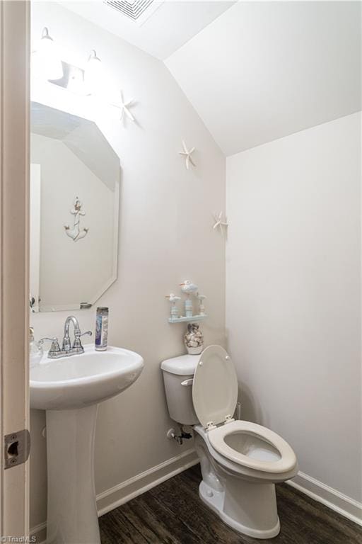 bathroom with toilet, vaulted ceiling, and wood-type flooring