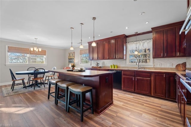 kitchen featuring a chandelier, pendant lighting, black dishwasher, and a center island