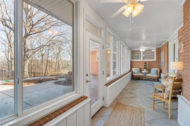 sunroom featuring ceiling fan and a healthy amount of sunlight