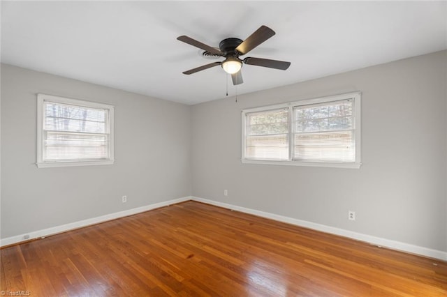 spare room with wood-type flooring, plenty of natural light, and ceiling fan