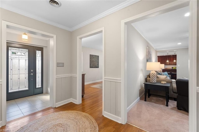 entryway featuring light wood-type flooring and crown molding