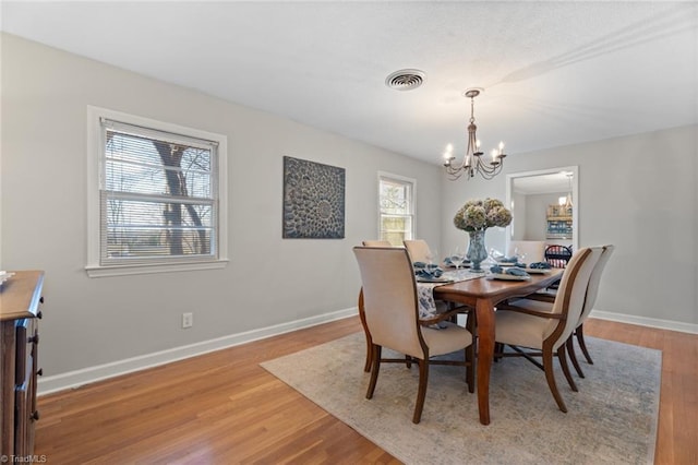 dining room featuring a notable chandelier and light wood-type flooring