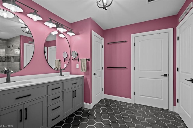 bathroom featuring tiled shower and vanity