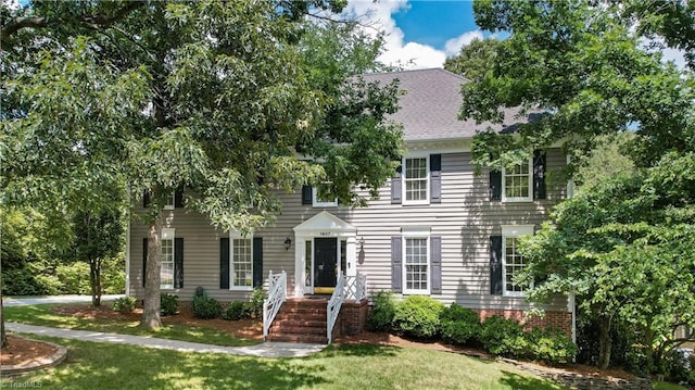 1807 Millhouse Ct, Greensboro, NC 27407 - colonial house featuring a front lawn and roof with shingles