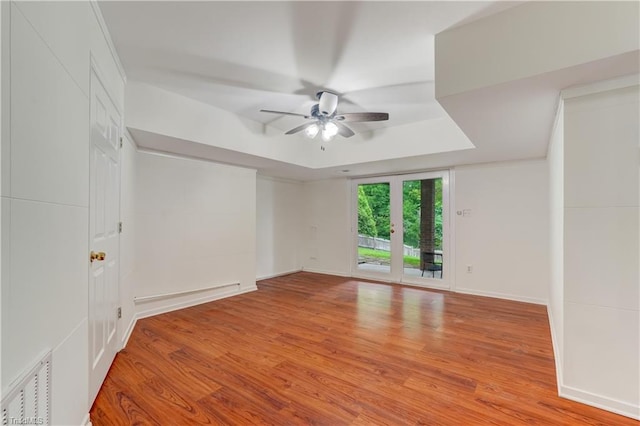 1807 Millhouse Ct, Greensboro, NC 27407 - empty room featuring a ceiling fan, wood finished floors, and a raised ceiling