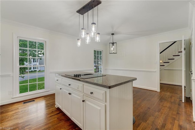 1807 Millhouse Ct, Greensboro, NC 27407 - kitchen featuring black electric cooktop, ornamental molding, dark wood-style floors, white cabinets, and hanging light fixtures