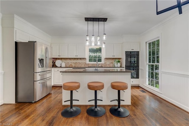 1807 Millhouse Ct, Greensboro, NC 27407 - kitchen featuring stainless steel fridge with ice dispenser, healthy amount of natural light, dark wood finished floors, a center island, and crown molding