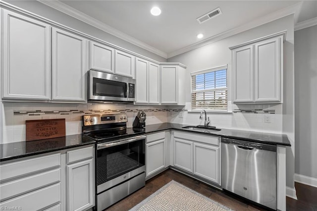 kitchen with dark hardwood / wood-style flooring, sink, white cabinetry, and stainless steel appliances