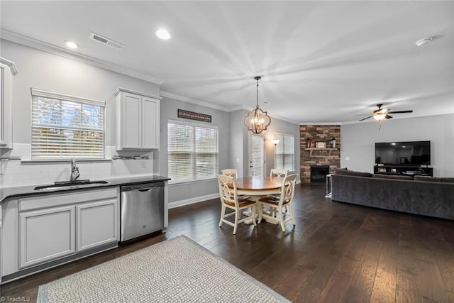 kitchen featuring decorative backsplash, plenty of natural light, stainless steel dishwasher, and dark hardwood / wood-style floors
