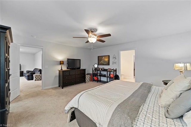 carpeted bedroom featuring ensuite bath and ceiling fan