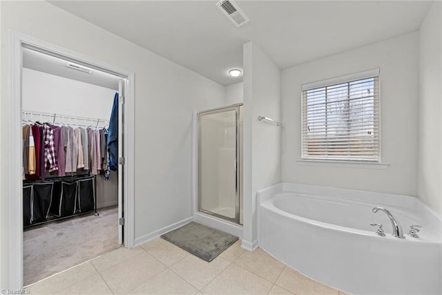 bathroom with tile patterned floors and shower with separate bathtub