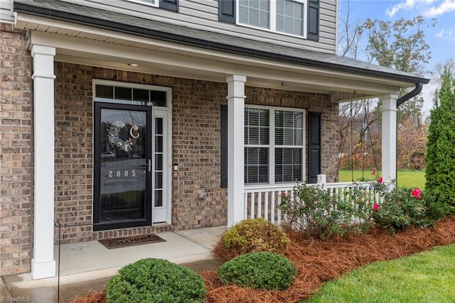 view of exterior entry featuring covered porch