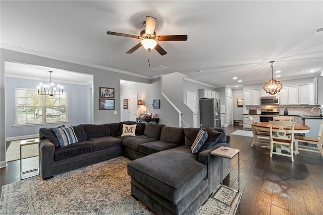 living room featuring ceiling fan with notable chandelier, dark hardwood / wood-style floors, crown molding, and sink