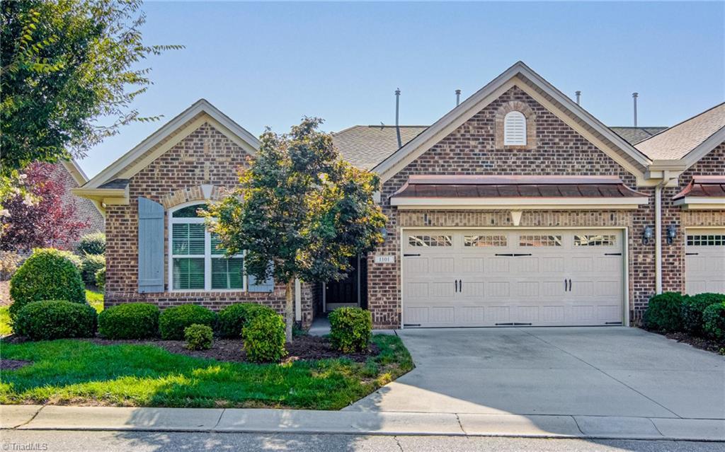 1101 Friedberg Village Dr, Winston-Salem, NC 27127 - view of front facade featuring metal roof, a garage, brick siding, concrete driveway, and a standing seam roof