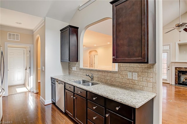 kitchen featuring visible vents, backsplash, dark wood-type flooring, a sink, and dishwasher