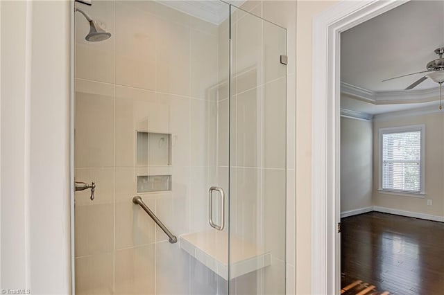 full bathroom with baseboards, ceiling fan, ornamental molding, wood finished floors, and a shower stall