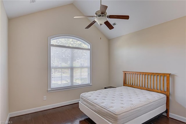 bedroom with dark wood-type flooring, lofted ceiling, visible vents, and baseboards