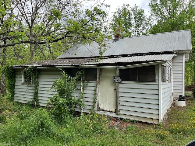 exterior space with a chimney and metal roof