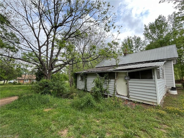 back of house featuring metal roof