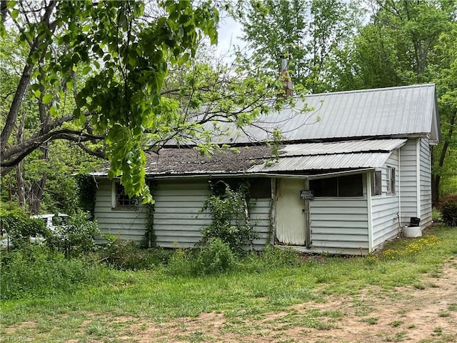 back of house featuring metal roof