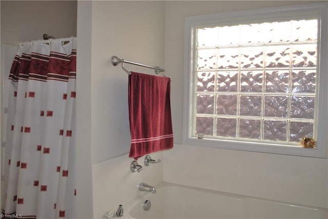 bathroom with shower with separate bathtub and a healthy amount of sunlight