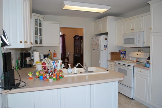 kitchen featuring kitchen peninsula, white appliances, and white cabinets