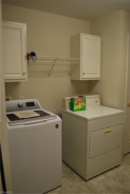 laundry room featuring cabinets and washer and clothes dryer