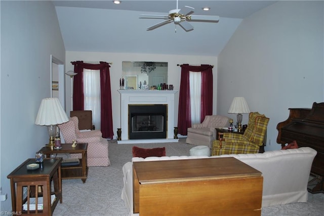 carpeted living room with ceiling fan and lofted ceiling