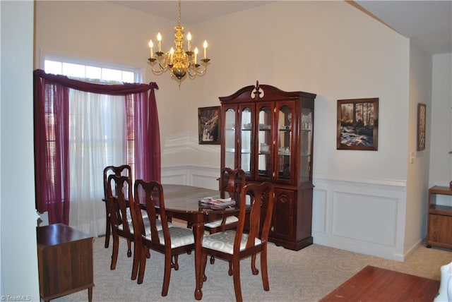 dining area featuring light carpet and a chandelier