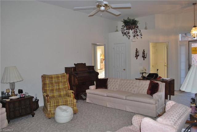 living room with ceiling fan, a high ceiling, and light carpet