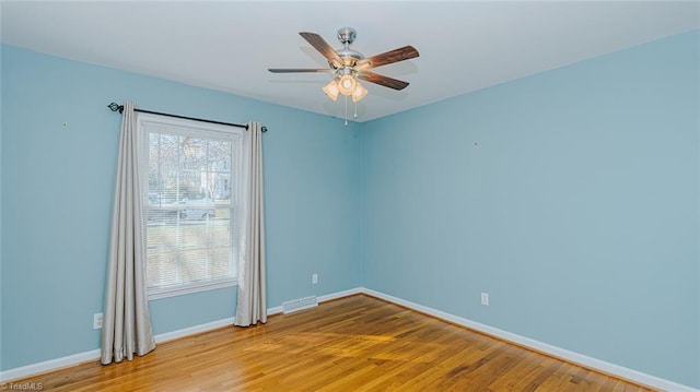 empty room featuring ceiling fan, wood-type flooring, and a healthy amount of sunlight