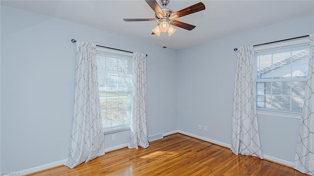 spare room featuring ceiling fan, a wealth of natural light, and hardwood / wood-style flooring