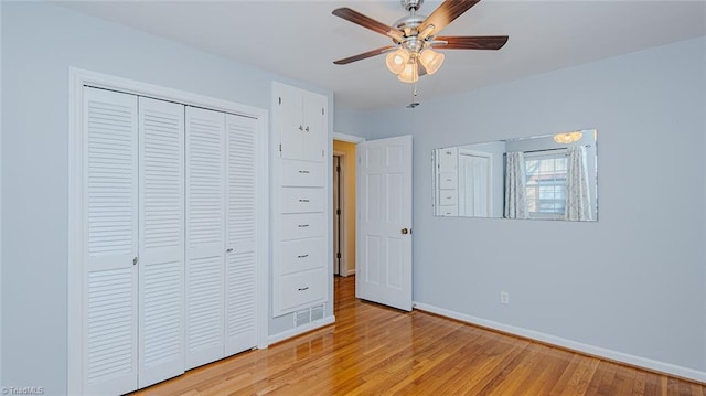 unfurnished bedroom featuring ceiling fan, a closet, and light wood-type flooring