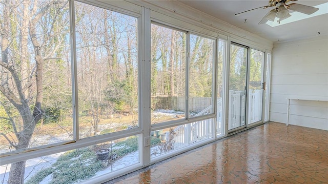 unfurnished sunroom with ceiling fan