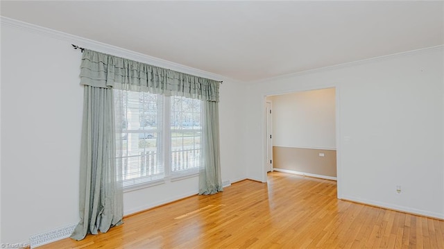 empty room featuring ornamental molding and hardwood / wood-style floors