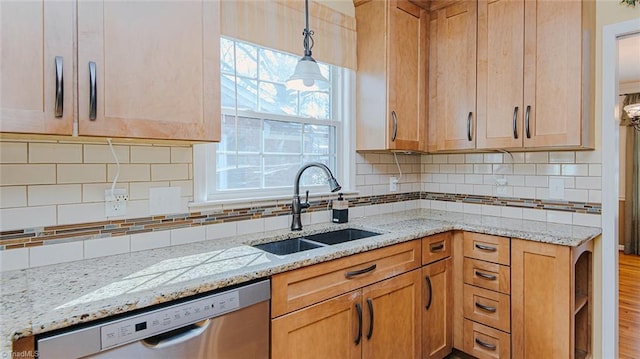 kitchen with backsplash, decorative light fixtures, dishwasher, light stone countertops, and sink